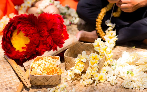 Lei making with yellow flowers at Na Lei Aloha Luau, Waikīkī.