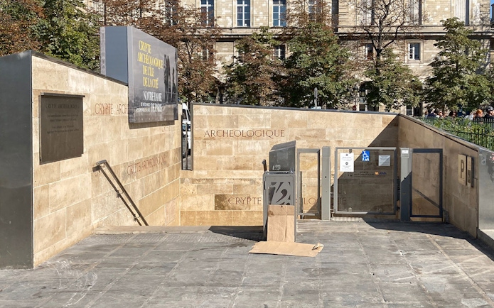 Notre Dame Archaeological Crypt entrance in Paris with informational signage.