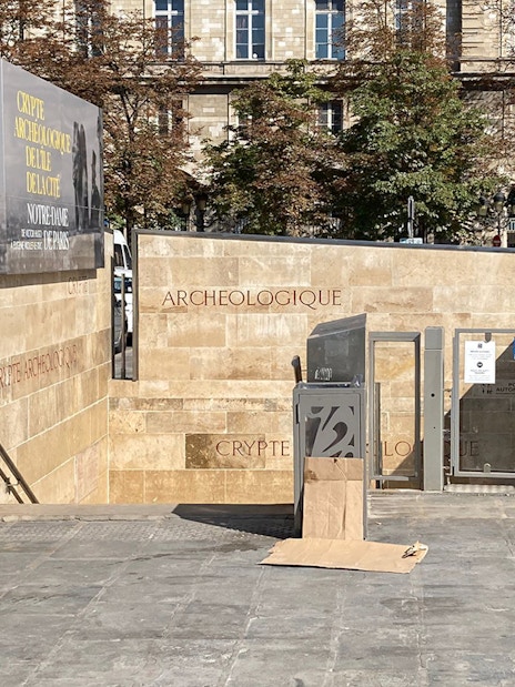 Notre Dame Archaeological Crypt entrance in Paris with informational signage.