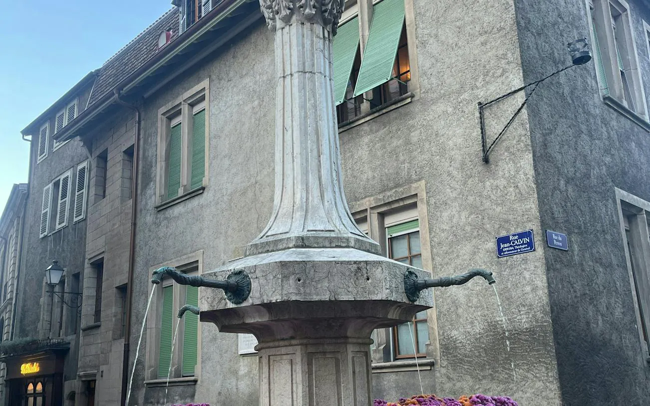 Historic fountain on Rue Jean-Calvin in Geneva, part of the self-guided city exploration game.