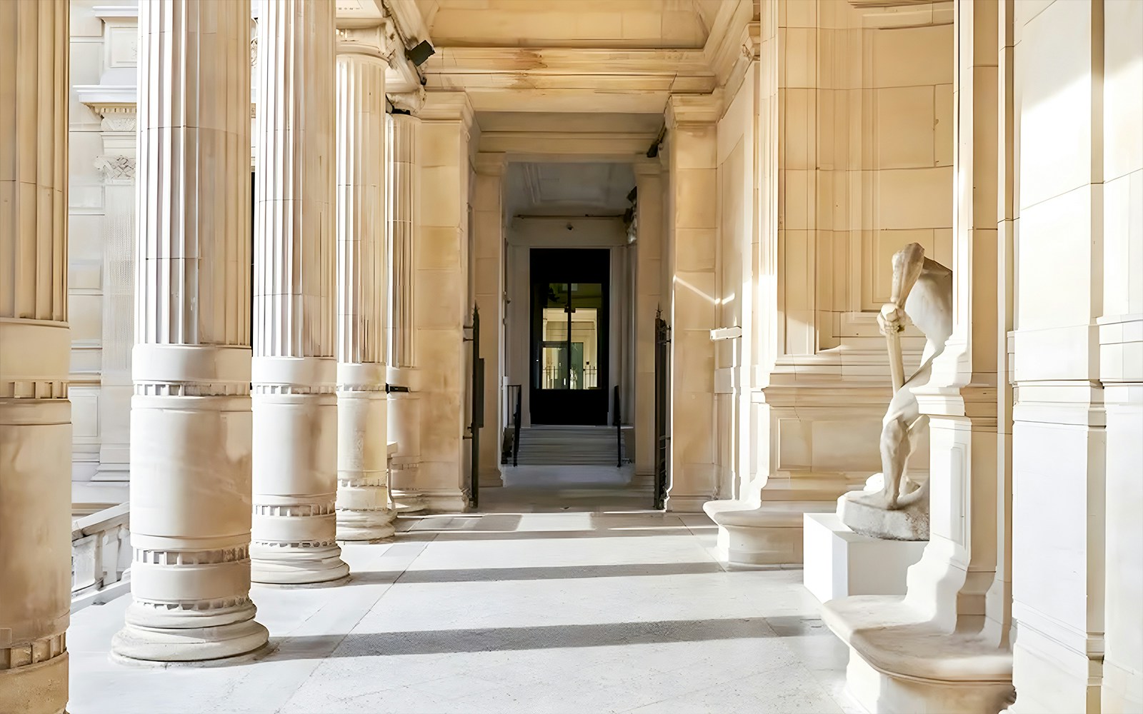 Palais Galliera corridors with columns and a statue in Paris.