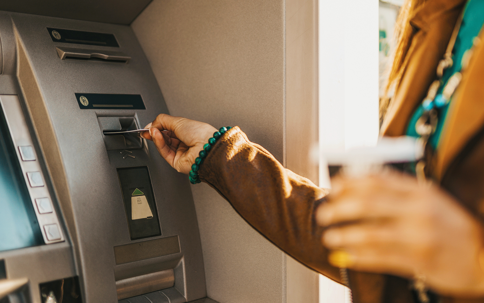 Inserting card into ATM machine.