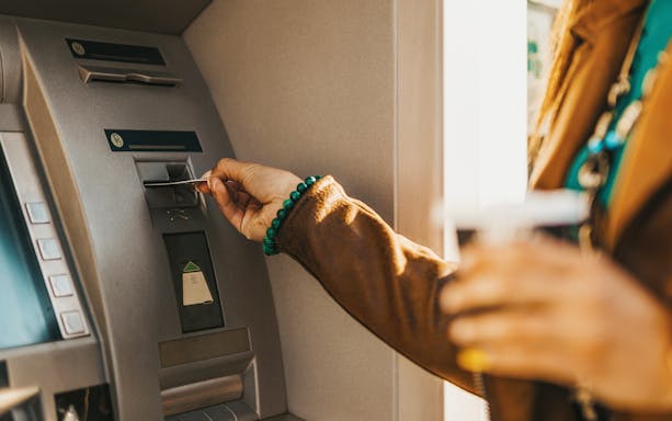 Inserting card into ATM machine.