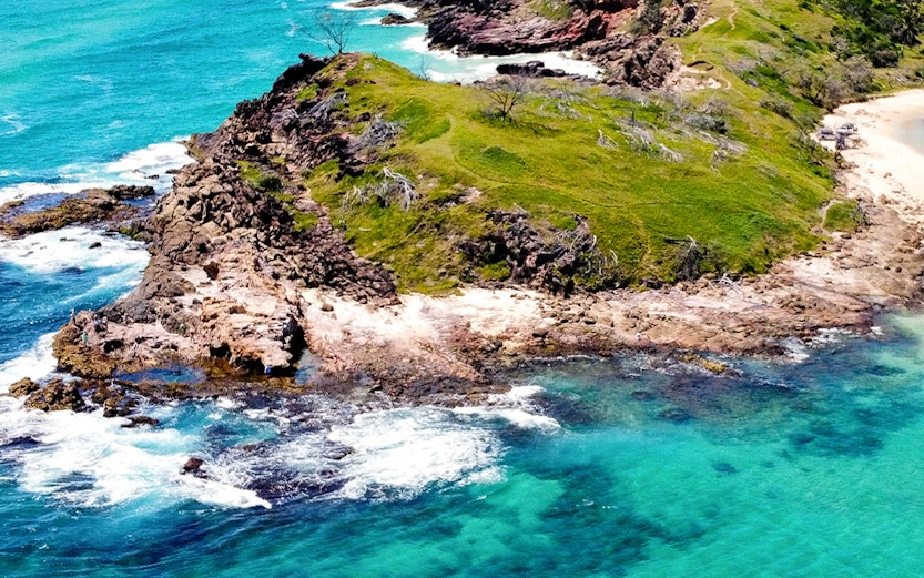 Aerial view of rocky coastline and turquoise waters on Fraser Island, Australia.