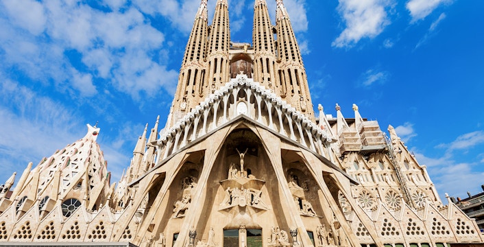 Sagrada Familia entrance with detailed facade and spires in Barcelona, Spain.