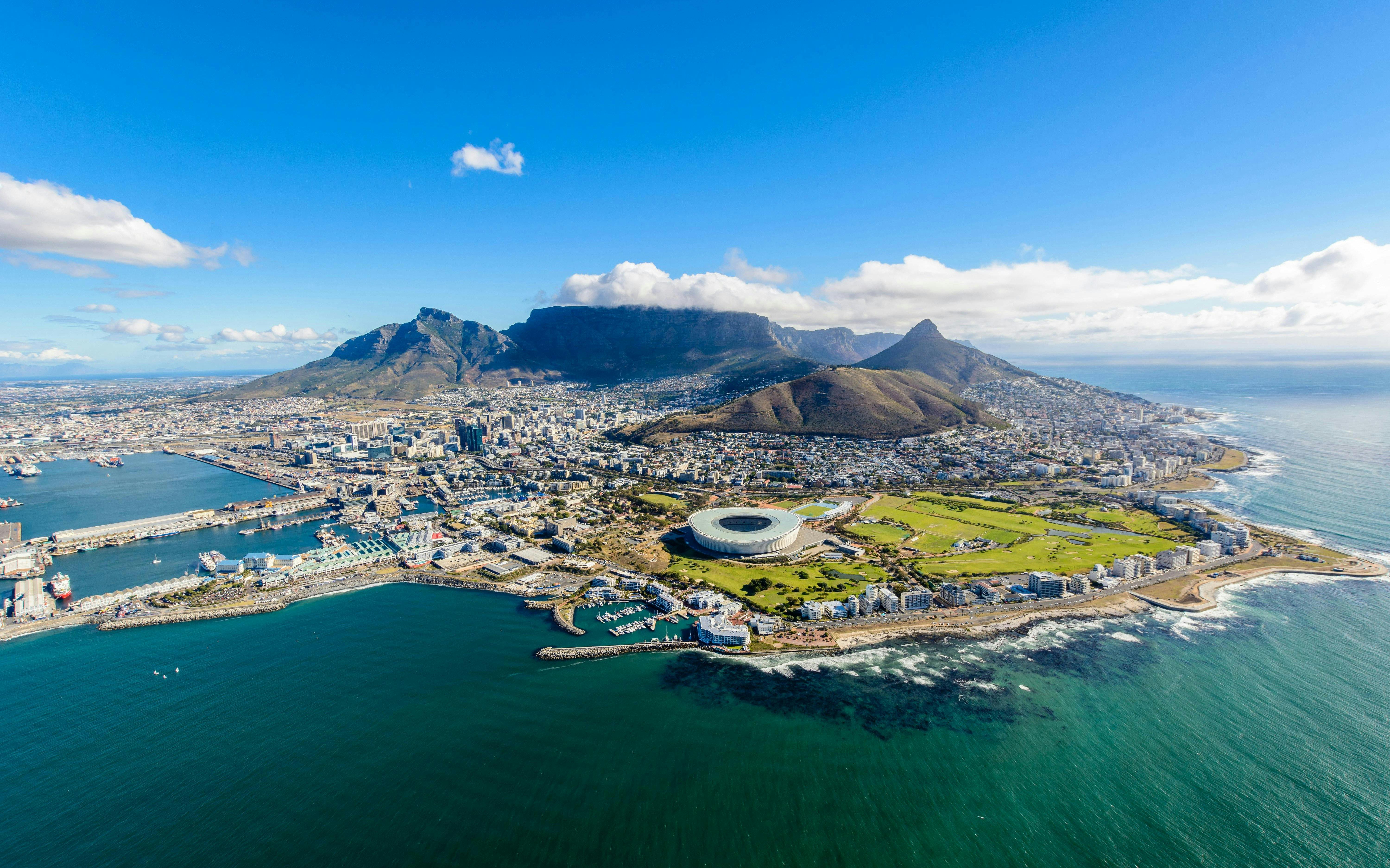 Aerial view of Cape Town with Table Mountain and the stadium by the coastline.
