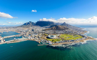 Aerial view of Cape Town with Table Mountain and the stadium by the coastline.