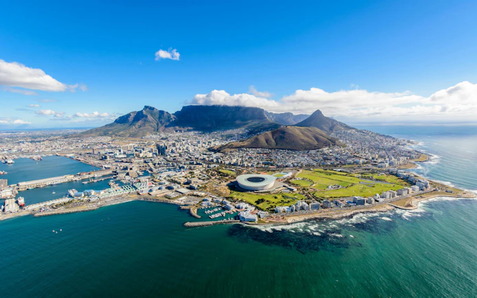 Aerial view of Cape Town with Table Mountain and the stadium by the coastline.