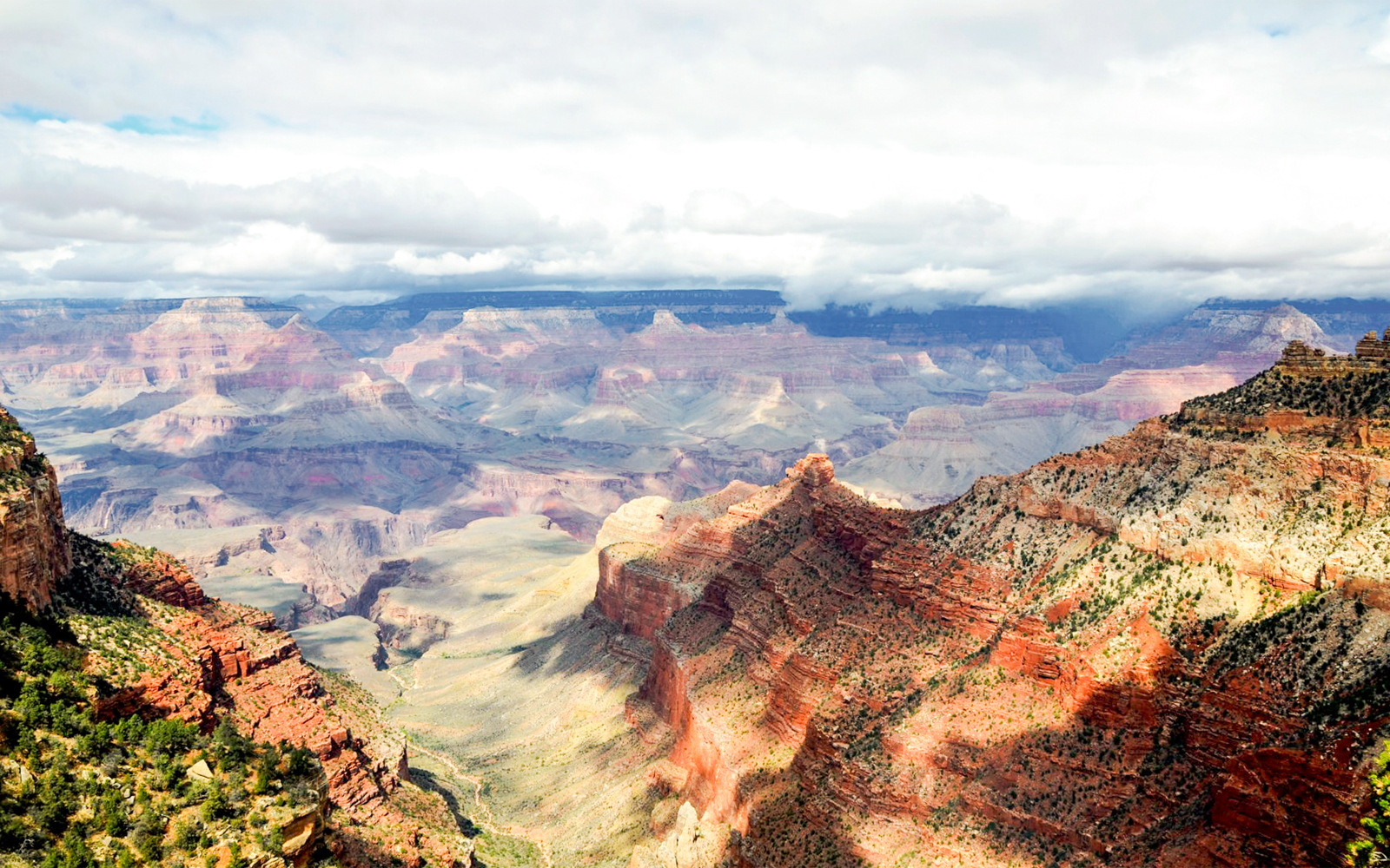 Aerial view of the Grand Canyon with a helicopter flying over the canyon's vast landscape in Las Vegas.