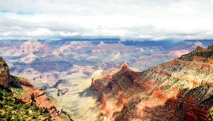 Aerial view of the Grand Canyon with a helicopter flying over the canyon's vast landscape in Las Vegas.