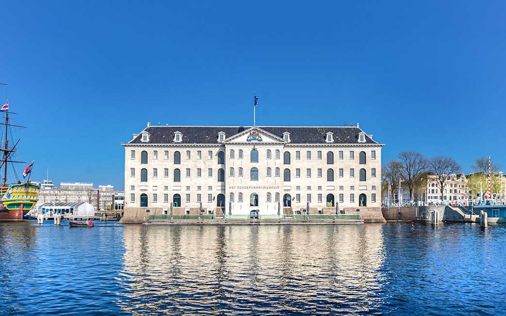 National Maritime Museum in Amsterdam with docked ship and waterfront view.