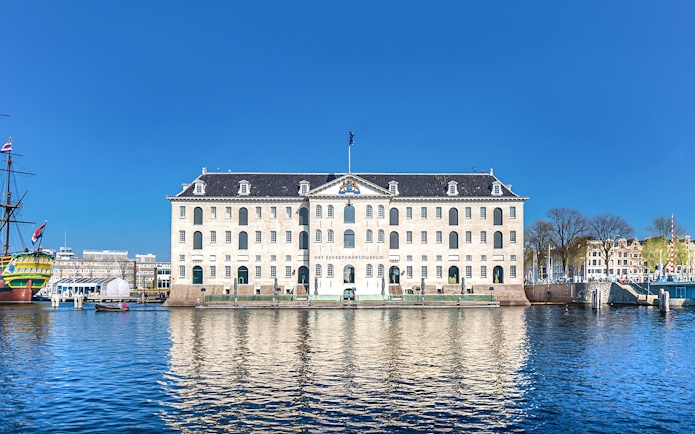 National Maritime Museum in Amsterdam with docked ship and waterfront view.