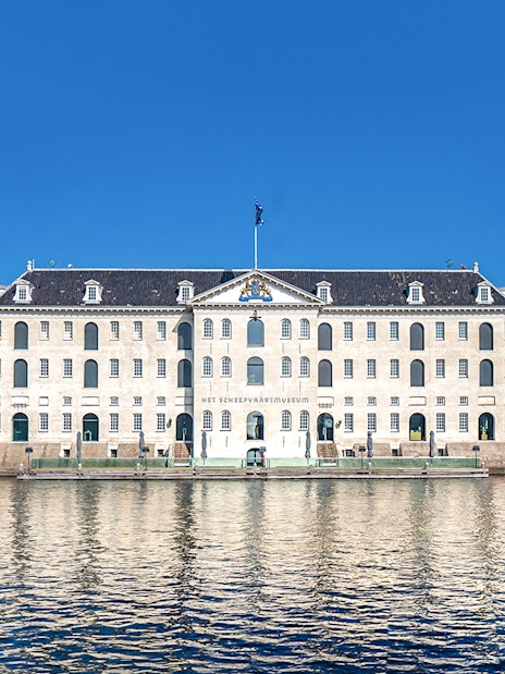 National Maritime Museum in Amsterdam with docked ship and waterfront view.