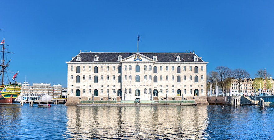 National Maritime Museum in Amsterdam with docked ship and waterfront view.