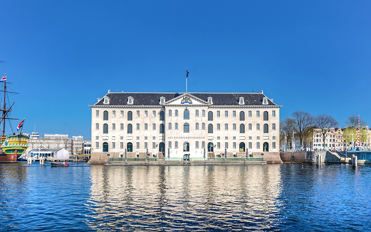 National Maritime Museum in Amsterdam with docked ship and waterfront view.