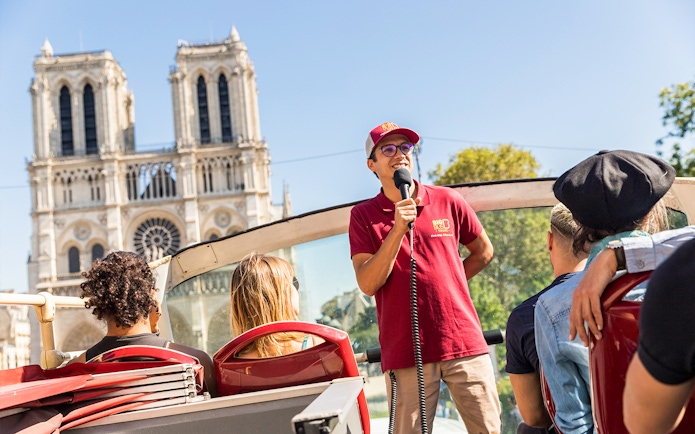 Tour guide speaking on Big Bus near Notre-Dame Cathedral, Paris.
