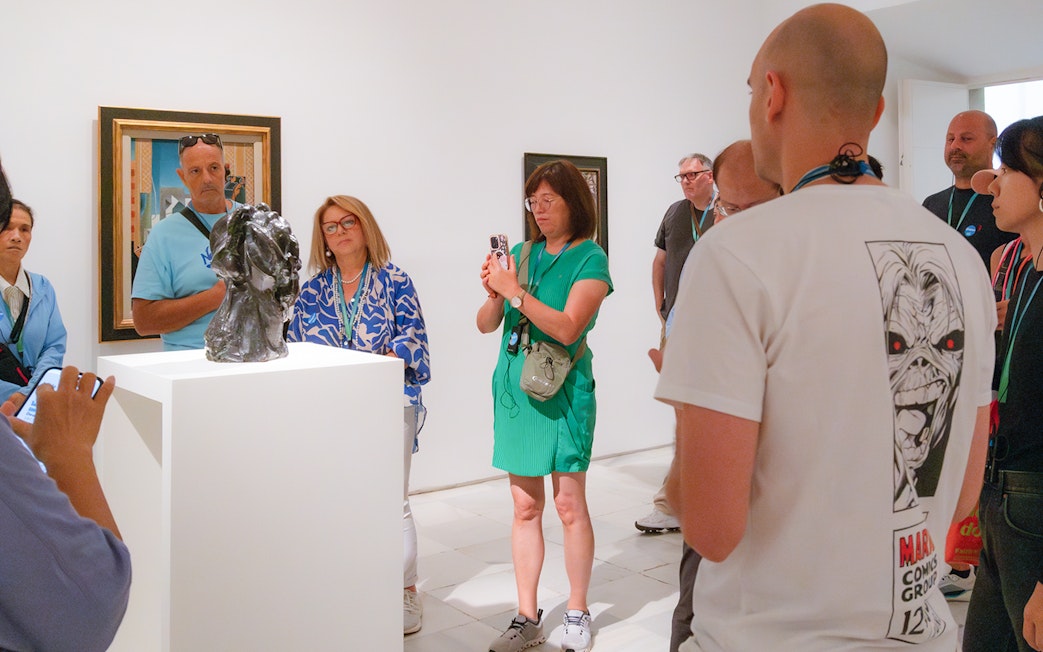 Visitors observing sculpture during Prado & Reina Sofia Museum guided tour.