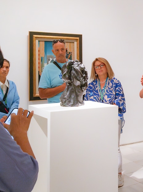 Visitors observing sculpture during Prado & Reina Sofia Museum guided tour.
