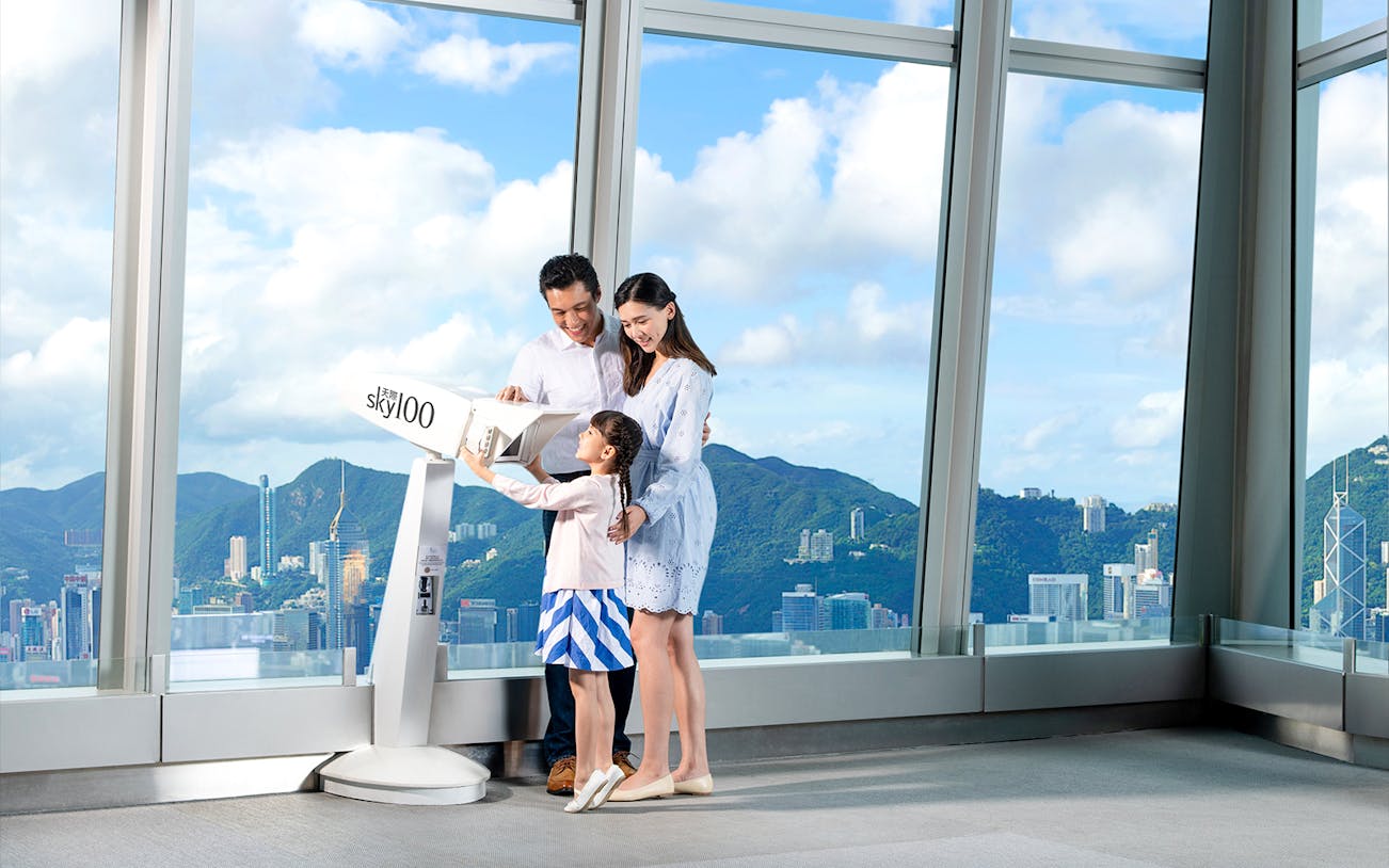 Family enjoying the view from Sky100 observation deck in Hong Kong.