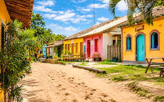 Colorful houses along a sandy street in Caraíva, Porto Seguro, Brazil.