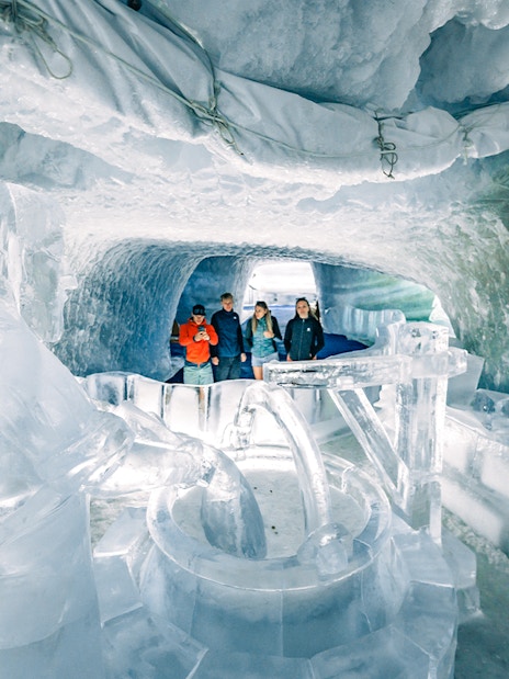 Tourists exploring ice sculptures inside Glacier Palace at Matterhorn Glacier.