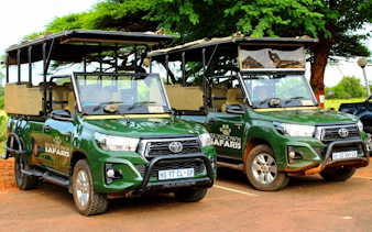 Safari vehicles at Pilanesberg Nature Reserve parking area.