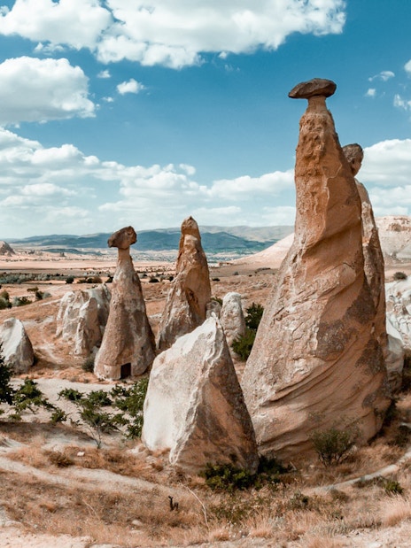 Fairy chimneys in Cappadocia under a blue sky, part of the Red Tour experience.