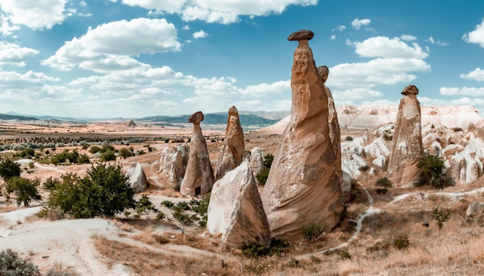 Fairy chimneys in Cappadocia under a blue sky, part of the Red Tour experience.