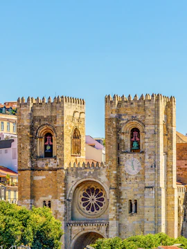 Lisbon Cathedral twin towers with rose window and clock face.
