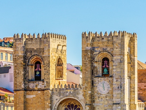 Lisbon Cathedral twin towers with rose window and clock face.