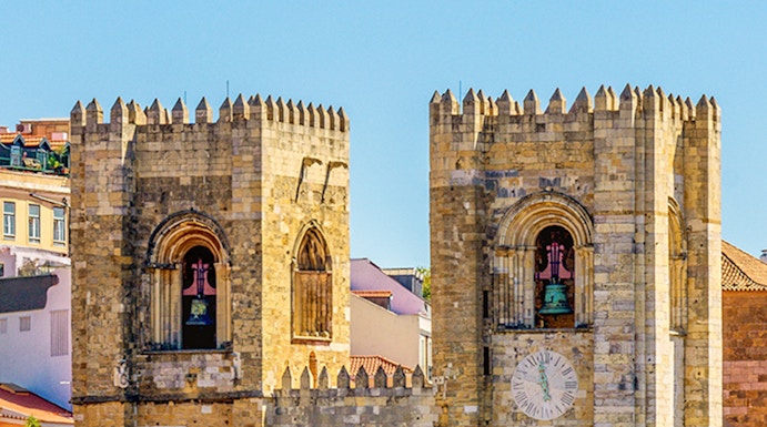 Lisbon Cathedral twin towers with rose window and clock face.