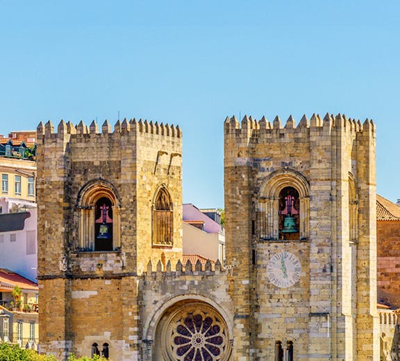 Lisbon Cathedral twin towers with rose window and clock face.