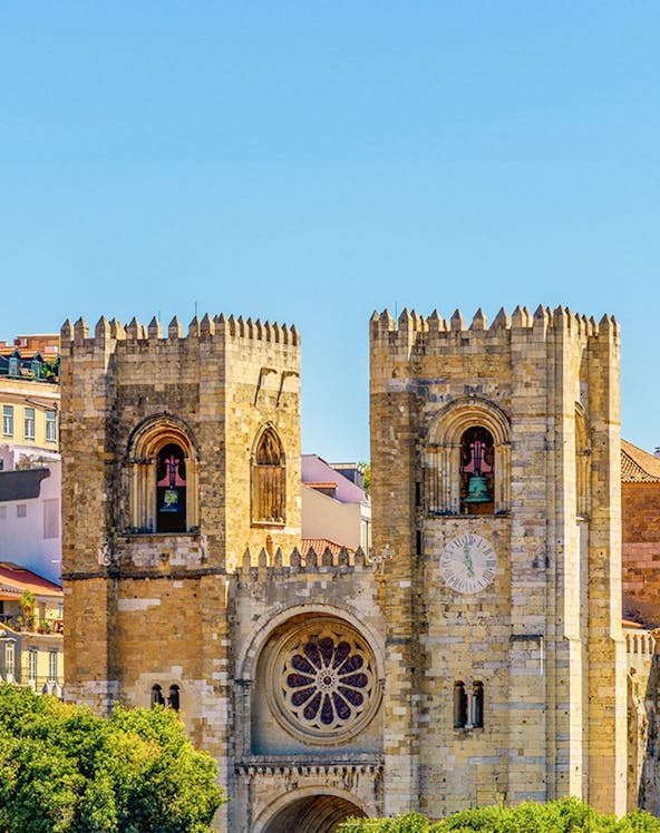 Lisbon Cathedral twin towers with rose window and clock face.