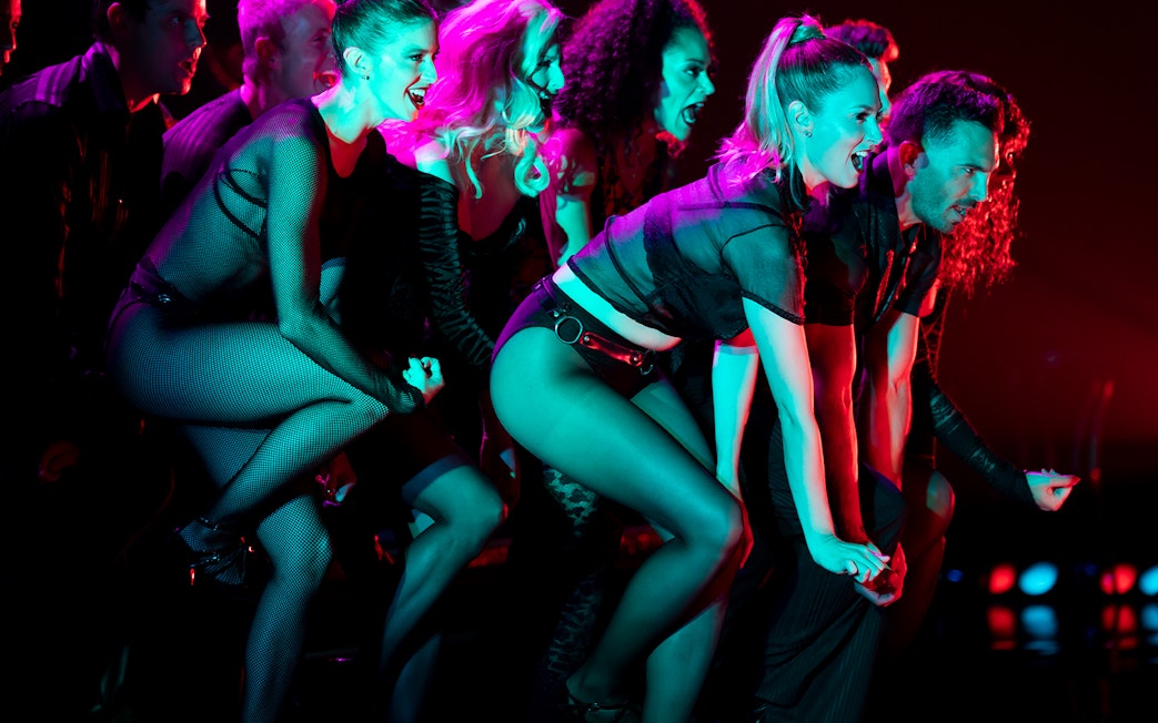 Performers dancing energetically in a Chicago theater show.