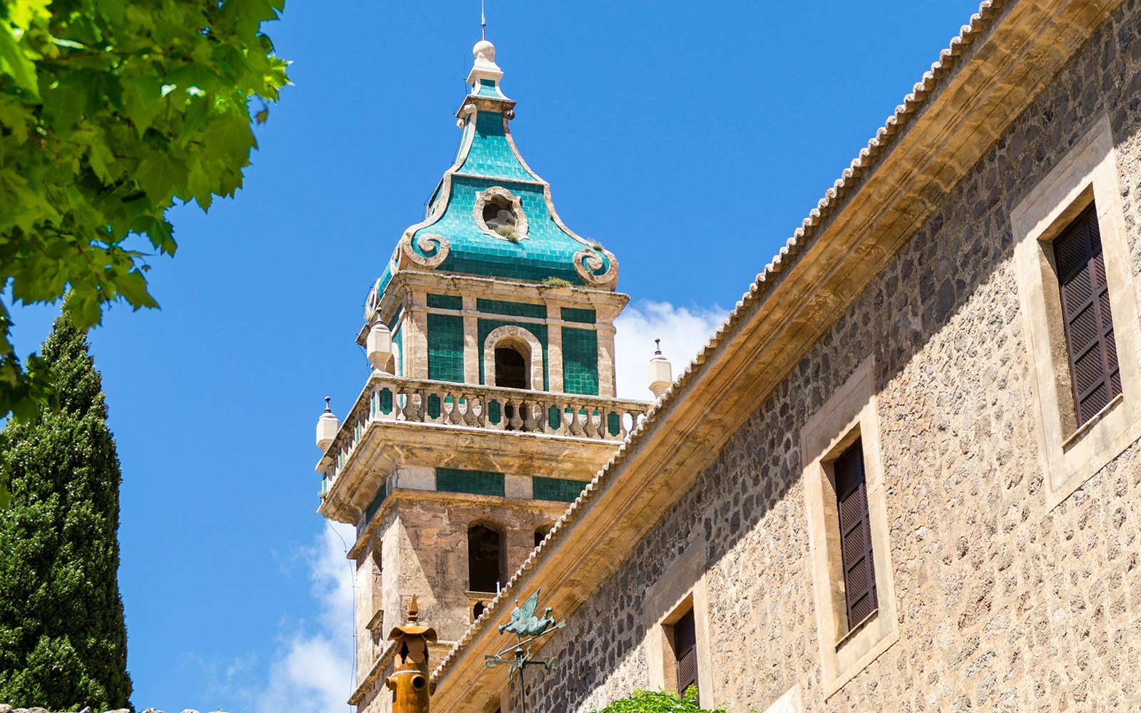 Bell Tower in Mallorca with turquoise tiles against a clear blue sky.