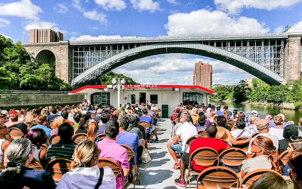 Passengers on a Circle Line cruise under a New York City bridge.