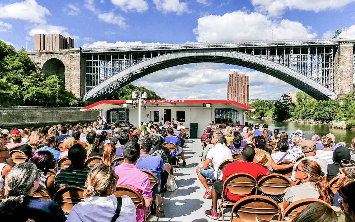 Passengers on a Circle Line cruise under a New York City bridge.