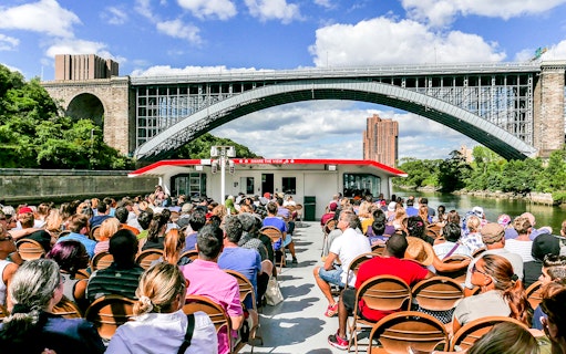 Passengers on a Circle Line cruise under a New York City bridge.