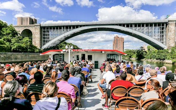 Passengers on a Circle Line cruise under a New York City bridge.