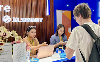 Bali airport SIM card collection counter with staff assisting a traveler.