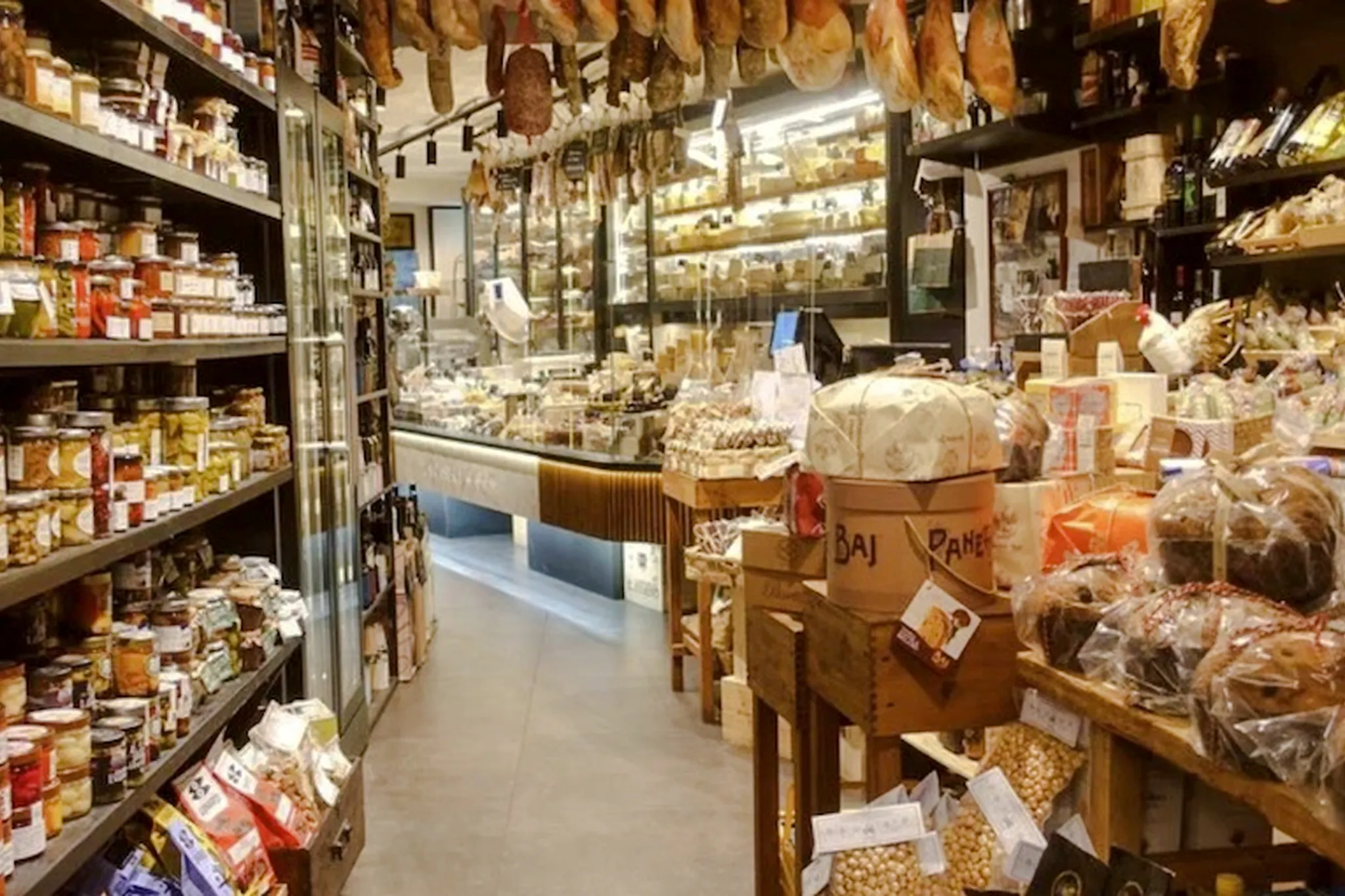 Italian deli with hanging cured meats and shelves of gourmet products, Florence Walking Tour.