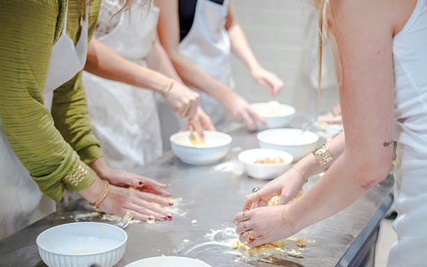 Participants preparing dough in a small group cooking class in Florence.