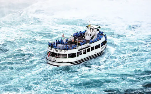 Boat with passengers in raincoats near Niagara Falls.