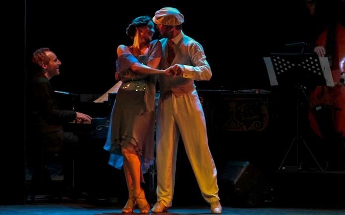 Dancers performing at Homero Manzi Tango Show with live musicians in Buenos Aires.