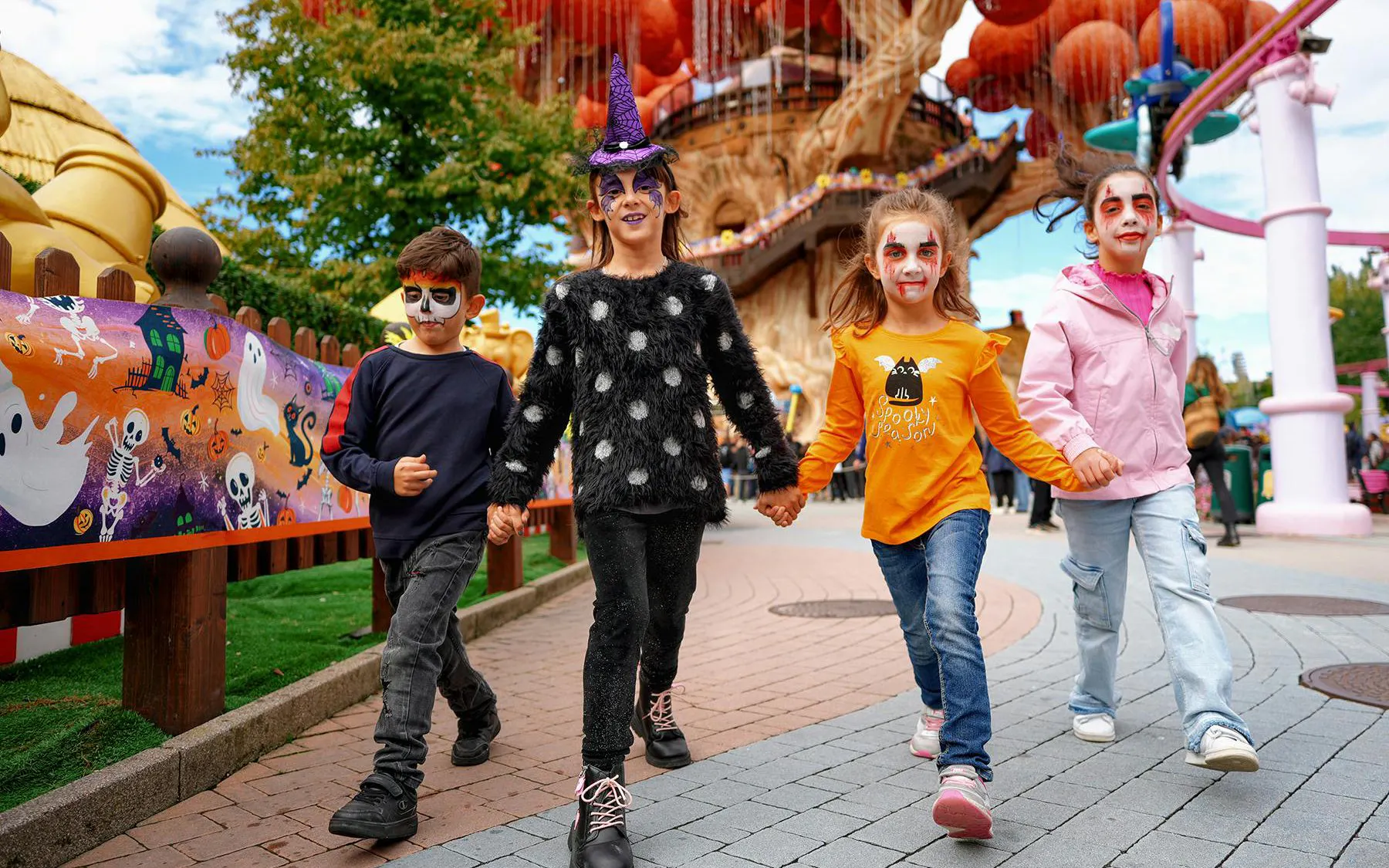 Children in Halloween costumes walking at Gardaland theme park.
