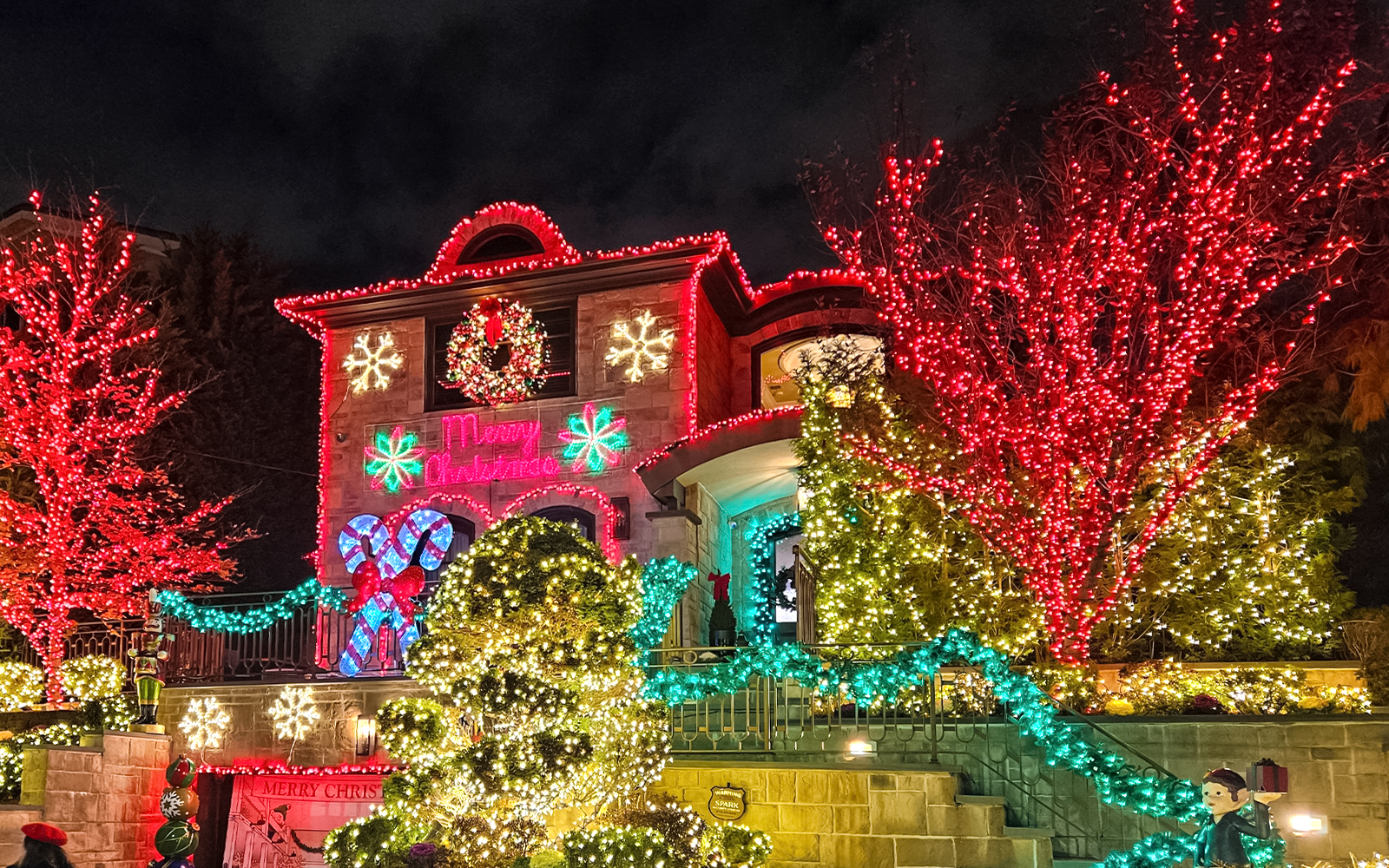 Festive house adorned with colorful Christmas lights on New York Christmas Lights Bus Tour.