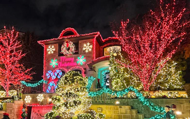 Festive house adorned with colorful Christmas lights on New York Christmas Lights Bus Tour.