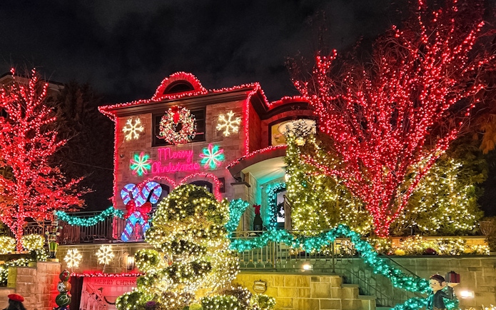 Festive house adorned with colorful Christmas lights on New York Christmas Lights Bus Tour.