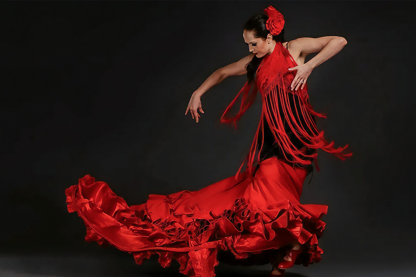 Flamenco dancer in red dress performing in Triana, Seville.