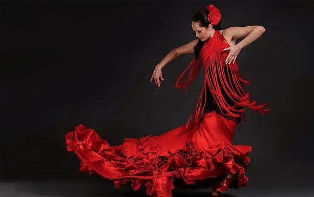 Flamenco dancer in red dress performing in Triana, Seville.